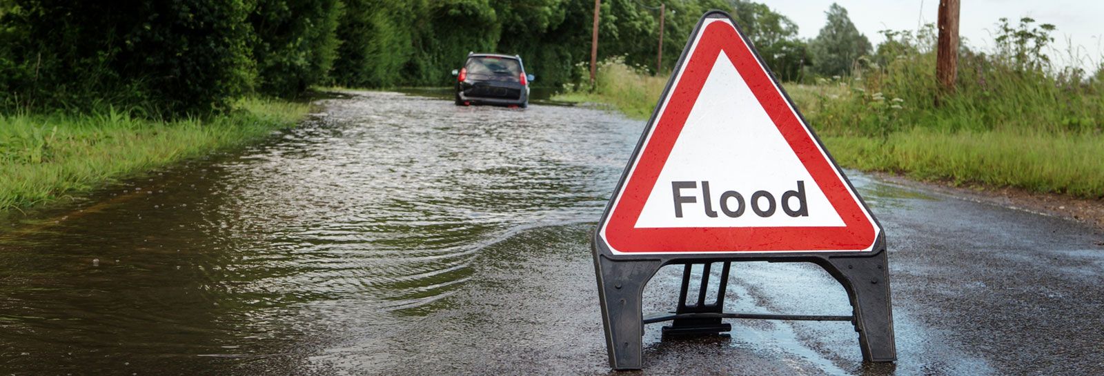 flooded road with warning sign banner image
